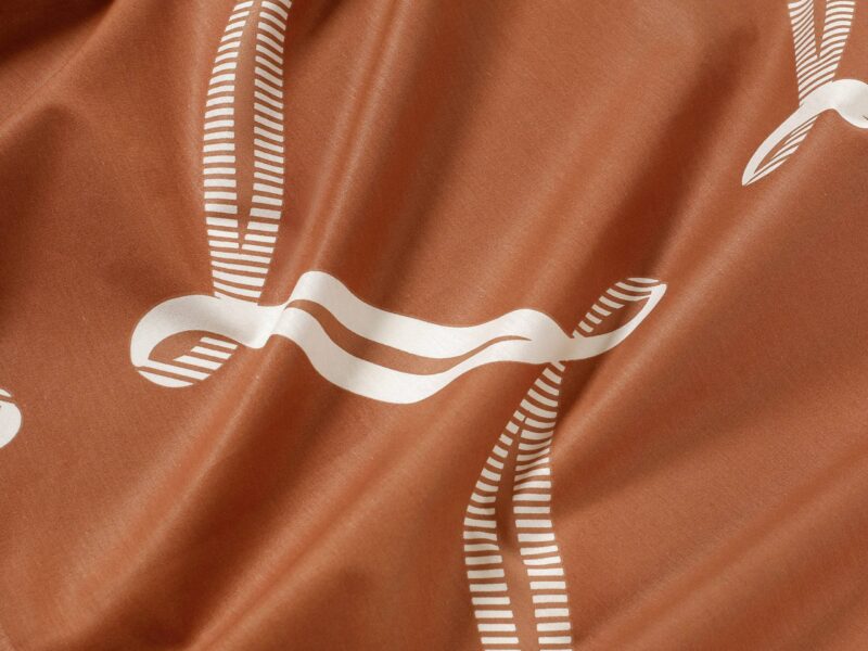 Cotton fabric white ribbon on brown by Stofex.