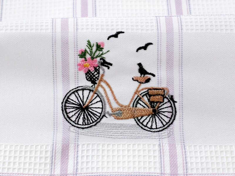 Waffle kitchen towel with bike and purple stripes from 100% cotton.