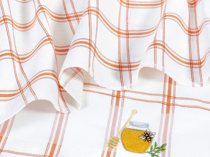 Waffle kitchen towel with honey jar and orange stripes from 100% cotton.