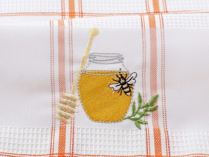 Waffle kitchen towel with honey jar and orange stripes from 100% cotton.